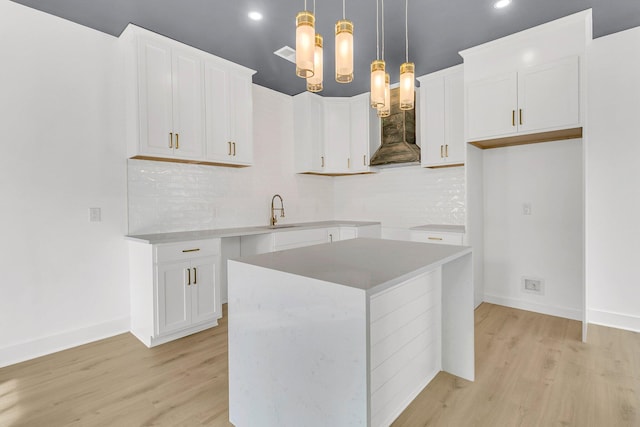 kitchen with a center island, backsplash, decorative light fixtures, white cabinetry, and a chandelier