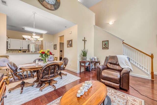 dining space with an inviting chandelier and dark hardwood / wood-style flooring