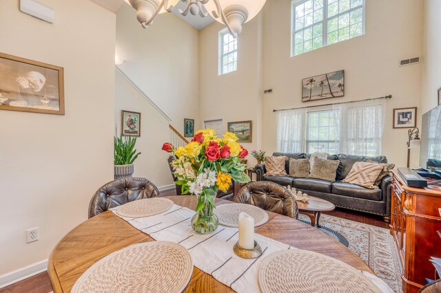 dining space featuring a towering ceiling and hardwood / wood-style floors