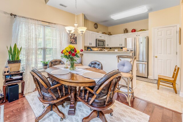 dining room featuring light hardwood / wood-style flooring and a notable chandelier