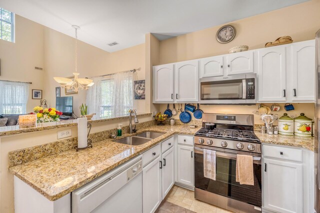 kitchen featuring appliances with stainless steel finishes, sink, white cabinets, and pendant lighting