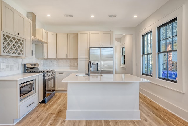 kitchen featuring a kitchen island with sink, light hardwood / wood-style flooring, stainless steel appliances, and sink