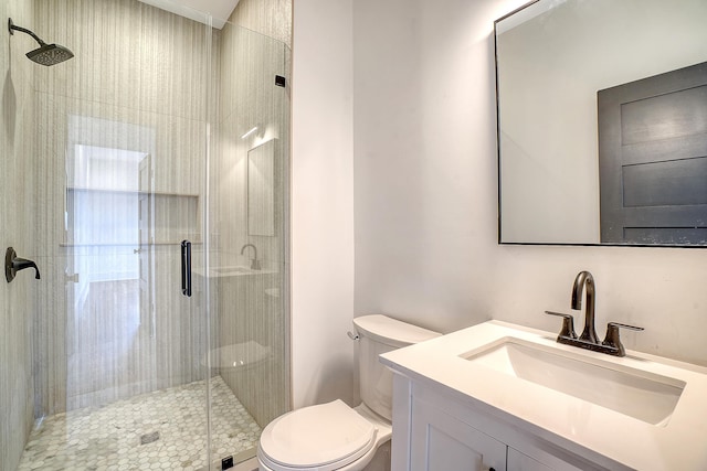 bathroom with walk in shower, vanity, and toilet