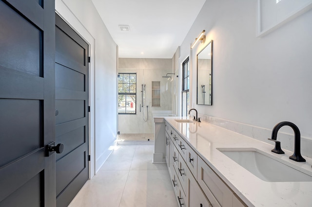 bathroom with tile patterned flooring, vanity, and walk in shower