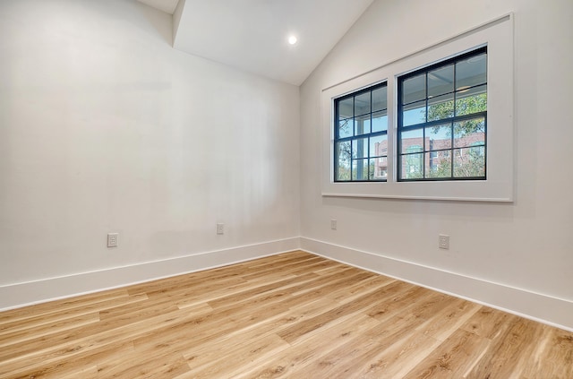 unfurnished room with wood-type flooring and vaulted ceiling