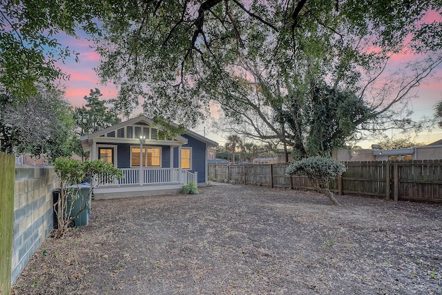 back house at dusk with a porch