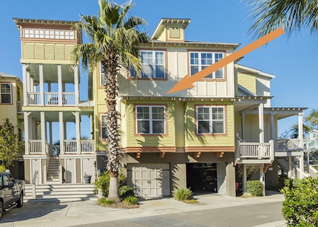 204 Michigan Avenue C-5 - Unit 11, Folly Beach, SC 29439 - view of front facade with stairway, a garage, covered porch, and driveway