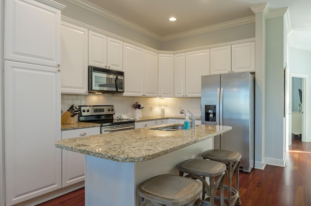 204 Michigan Avenue C-5 - Unit 11, Folly Beach, SC 29439 - kitchen with appliances with stainless steel finishes, crown molding, white cabinetry, dark wood-style flooring, and light stone countertops