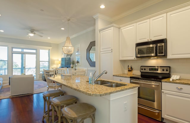 204 Michigan Avenue C-5 - Unit 11, Folly Beach, SC 29439 - kitchen with appliances with stainless steel finishes, light stone countertops, white cabinets, ornamental molding, and recessed lighting