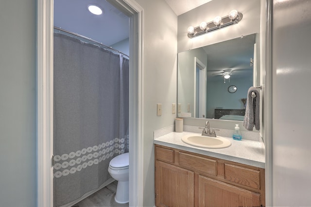 bathroom featuring ceiling fan, hardwood / wood-style floors, vanity, and toilet