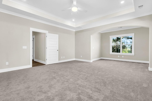 carpeted spare room featuring ornamental molding, ceiling fan, and a tray ceiling