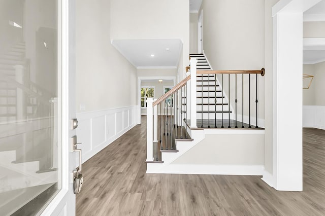 foyer entrance with crown molding and wood-type flooring