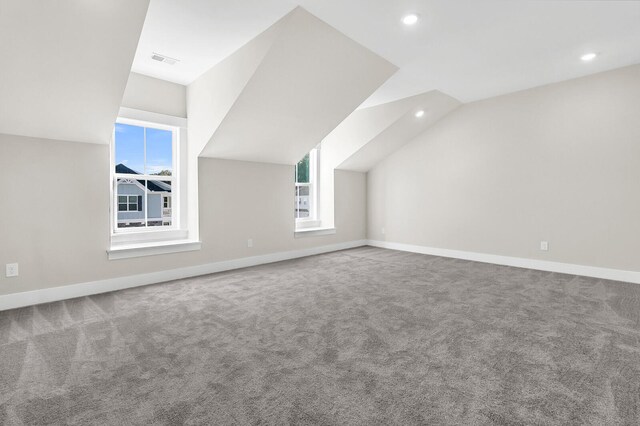 bonus room with lofted ceiling and carpet