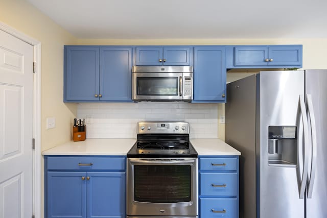 kitchen with blue cabinets, decorative backsplash, and appliances with stainless steel finishes