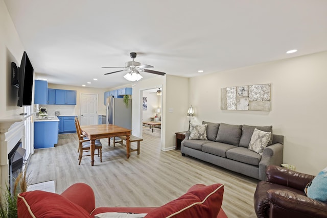 living room featuring light hardwood / wood-style flooring and ceiling fan