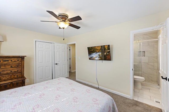 carpeted bedroom with ensuite bathroom, ceiling fan, and a closet