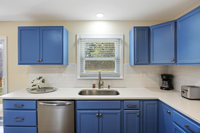 kitchen featuring blue cabinetry, stainless steel dishwasher, sink, and backsplash