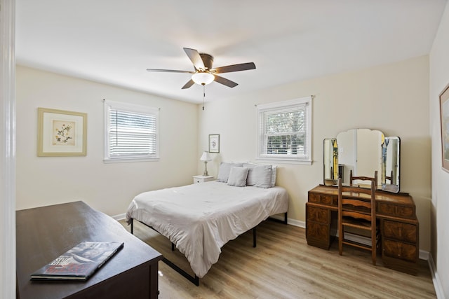 bedroom with ceiling fan, light hardwood / wood-style floors, and multiple windows