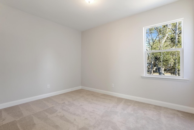 empty room with baseboards and light carpet