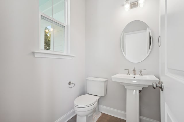 bathroom featuring toilet, baseboards, and wood finished floors