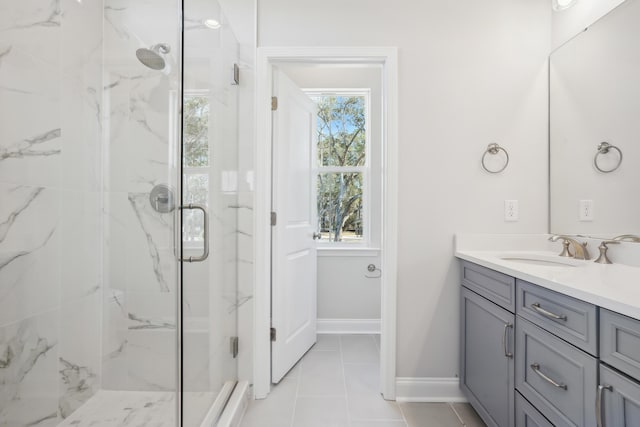 full bathroom featuring a marble finish shower, baseboards, and vanity