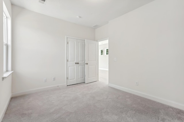 unfurnished bedroom featuring carpet flooring, baseboards, and a closet