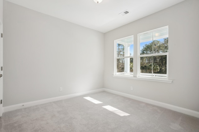 carpeted spare room featuring visible vents and baseboards