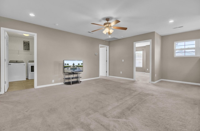 unfurnished living room featuring light carpet, ceiling fan, and washer and clothes dryer