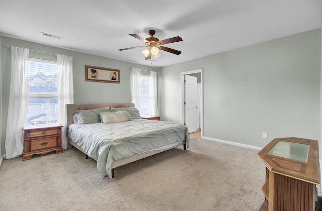 carpeted bedroom featuring ceiling fan and multiple windows