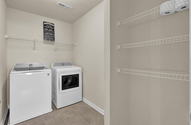 washroom with light tile patterned floors and washer and dryer