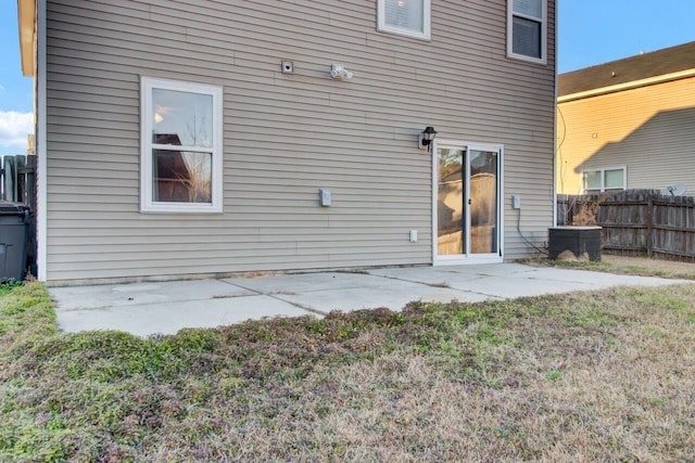 rear view of house with central AC unit and a patio