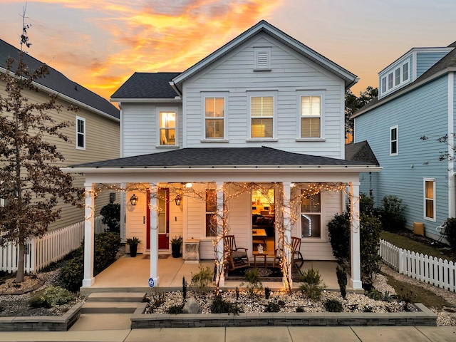 back house at dusk featuring a patio area