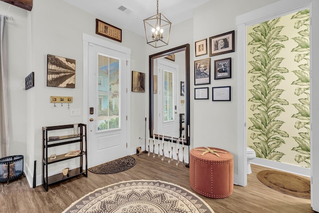 foyer entrance with wood-type flooring and a notable chandelier