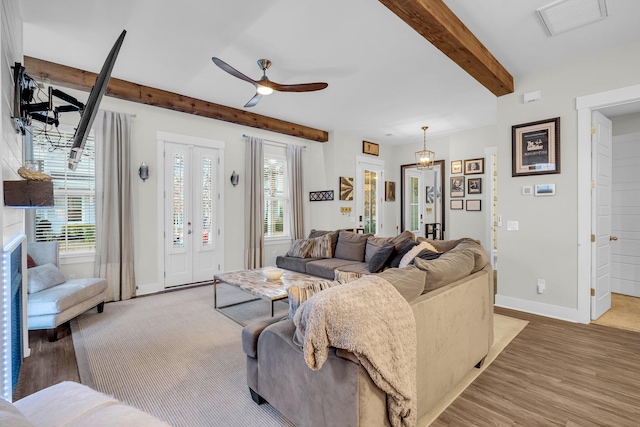 living room featuring beamed ceiling, wood-type flooring, and ceiling fan