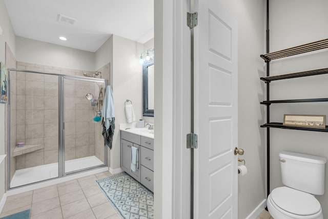 bathroom featuring vanity, tile patterned flooring, a shower with shower door, and toilet