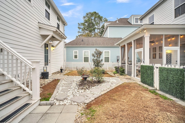 view of yard with a sunroom, cooling unit, and ceiling fan