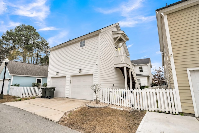 view of home's exterior with a garage and a balcony