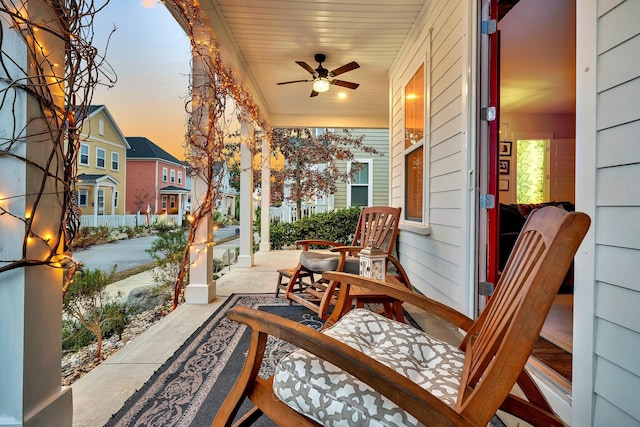 patio terrace at dusk with ceiling fan and a porch