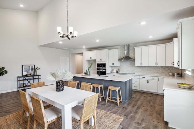453 White Magnolia St, Moncks Corner, SC 29461 - kitchen featuring wall chimney exhaust hood, dark wood-type flooring, a sink, black electric stovetop, and a kitchen island with sink