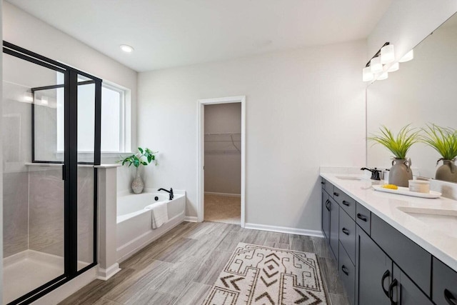 453 White Magnolia St, Moncks Corner, SC 29461 - bathroom featuring double vanity, a bath, a stall shower, wood finished floors, and a walk in closet