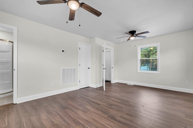 unfurnished bedroom with ensuite bath, dark hardwood / wood-style floors, and ceiling fan