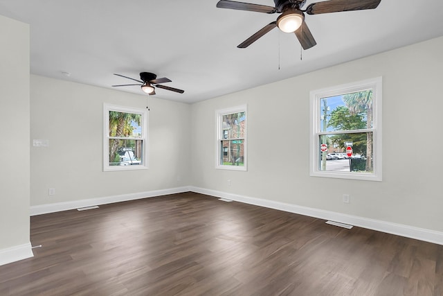 spare room featuring dark wood-type flooring and a healthy amount of sunlight