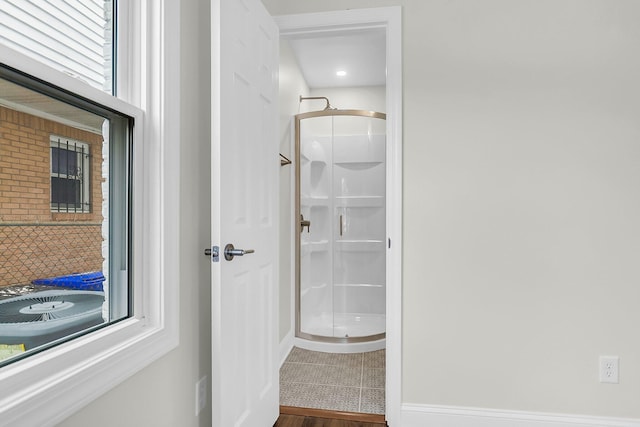 bathroom featuring wood-type flooring and a shower with door