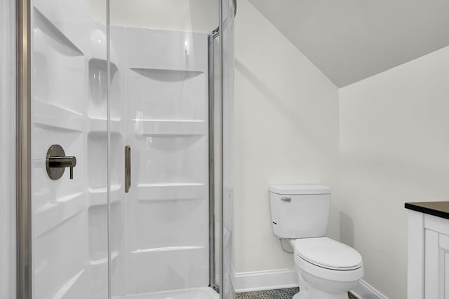 bathroom featuring toilet, vaulted ceiling, and a shower with shower door