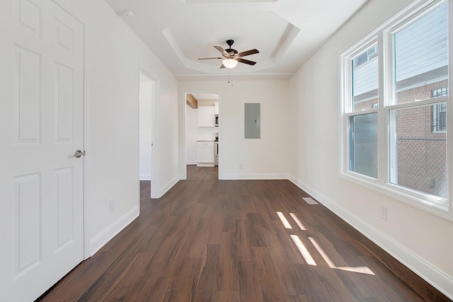 interior space featuring dark wood-type flooring, electric panel, and a raised ceiling