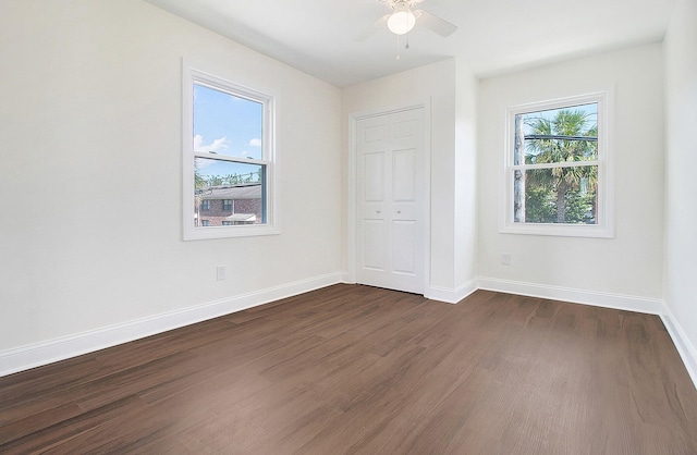 unfurnished bedroom with ceiling fan, dark hardwood / wood-style floors, and a closet