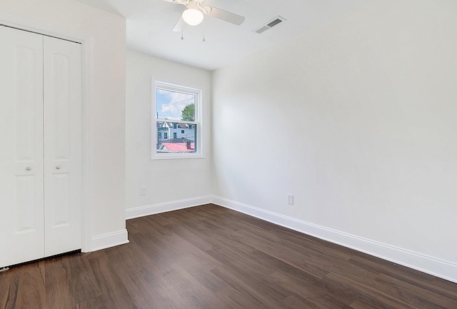 unfurnished bedroom featuring dark hardwood / wood-style flooring, a closet, and ceiling fan