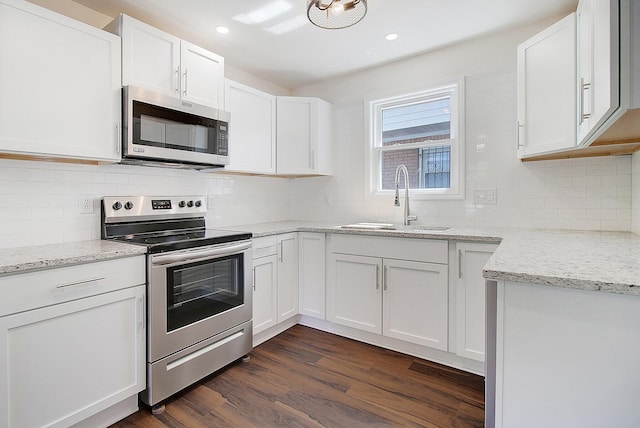 kitchen with white cabinetry, stainless steel appliances, sink, and dark hardwood / wood-style floors