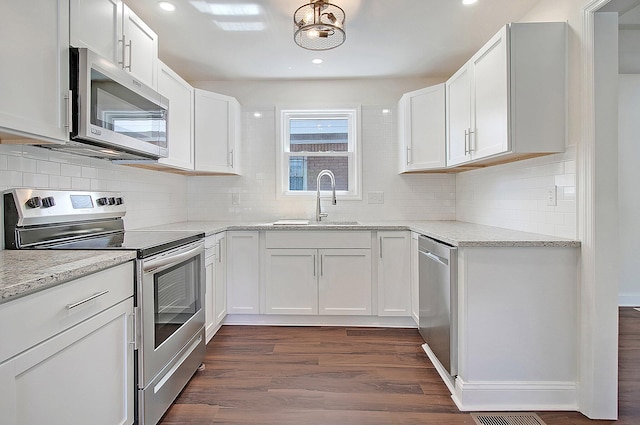 kitchen featuring white cabinetry, appliances with stainless steel finishes, and dark wood-type flooring