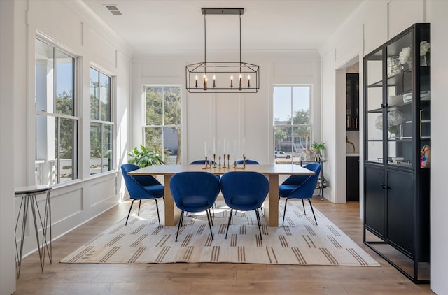 sunroom / solarium featuring a chandelier, plenty of natural light, and visible vents